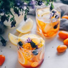 two glasses filled with orange slices and flowers