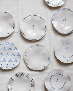 six plates with blue designs on them sitting on a table