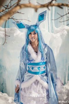 a woman with blue hair and bunny ears is dressed up in an ice princess costume