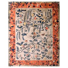 an orange and blue rug with floral designs on the bottom, in front of a white background