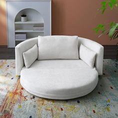 a white round chair sitting on top of a rug in front of a potted plant