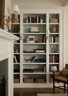 a living room filled with lots of furniture and bookshelves next to a fire place