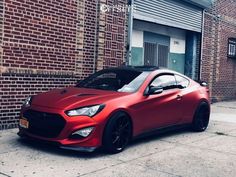 a red sports car parked in front of a brick building