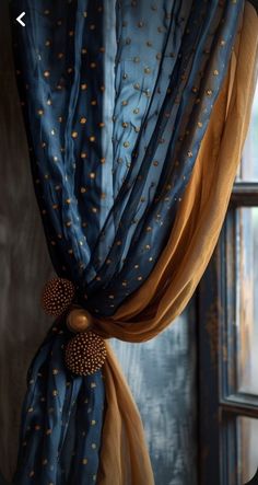 an open window with blue curtains and gold polka dots on the drapes in front of it