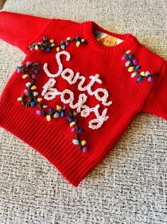 High quality knit sweater with Hand Embroidered "Santa baby" can be made with or without the Christmas lights! Choose your color sweater in personalizations if you don't want red! Turn around time for these sweaters are 3-5 days! Crochet Christmas Sweater, Toddler Ugly Christmas Sweater, Christmas Pinata, Embroidered Baby Sweater, Christmas Costumes Diy, Embroidered Christmas Sweater, Baby Christmas Outfits, Ugly Christmas Sweater Pattern, Baby Christmas Sweater