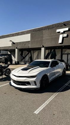 two white cars parked in front of a building