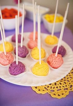 there are many small cupcakes on the plate with white sticks in each one