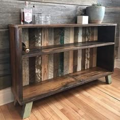 an old wooden shelf with some bottles on top of it and a potted plant next to it