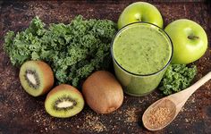 an assortment of fruits and vegetables on a table with a smoothie in the middle