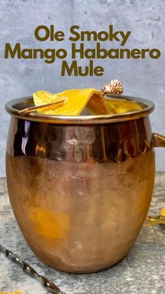 an old smoky mango habanero mule is served in a copper bowl with the words, ole smoky mango habanero mule