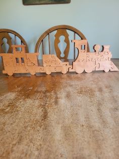 a wooden toy train set sitting on top of a table next to two circular pieces of wood