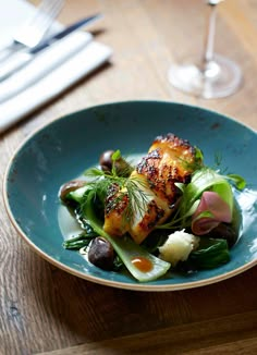 a blue plate topped with food on top of a wooden table