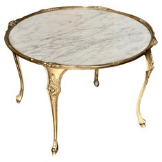 a white marble topped table with gold trimmings and an ornate design on the top