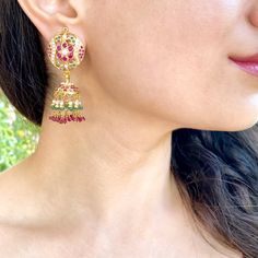 Featuring a pair of jadau jhumka earrings in 22k gold. This timeless piece adds a hint of sophistication and sparkle to any wardrobe, ensuring you look and feel your best no matter the occasion. This exquisite piece of jewelry is sure to become a treasured keepsake for years to come, making it the perfect gift for any occasion. The earrings weigh 23.59 gms including 3.98 gms in the hanging rubies, emeralds and pearls. 22k Gold Chandbali Jhumkas For Festive Occasions, 22k Gold Chandbali Danglers With Latkans, 22k Gold Meenakari Earrings For Navratri, 22k Gold Temple Jewelry Bridal Earrings With Latkans, 22k Gold Chandbalis With Latkans Temple Jewelry, 22k Gold Chandbali Jhumkas With Cutdana, 22k Gold Chandbali Bridal Earrings With Latkans, 22k Gold Meenakari Jhumkas For Wedding, Gift 22k Gold Meenakari Jhumkas