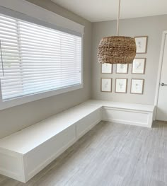 a white bench sitting under a window in a room