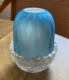 a blue glass vase sitting on top of a wooden table