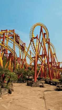 the roller coaster at six flags amusement park is painted orange and yellow with red details