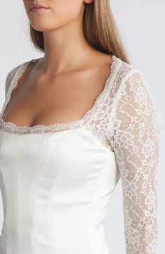 Sheer lace sleeves enhance the romance of a corset-inspired top fashioned with a smooth satin bodice and structured boning. Back zip; keyhole with button-and-loop closure Square neck Long sleeves Lined, with structured boning 100% polyester with 84% polyamide, 16% elastane and 90% polyamide, 10% elastane contrasts Dry clean Imported Elegant Corset With Lace Trim And Sweetheart Neckline, Elegant Corset With Sweetheart Neckline And Lace Trim, Elegant White Square Neck Corset, Elegant Corset With Sweetheart Neckline And Delicate Lace, Wedding Corset With Sweetheart Neckline And Lace Trim, Fitted Feminine Corset With Lace Bodice, Feminine Fitted Corset With Lace Bodice, Fitted Feminine Lace Top Corset, Feminine Fitted Lace Top Corset