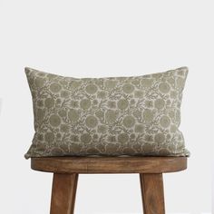 a pillow sitting on top of a wooden stool