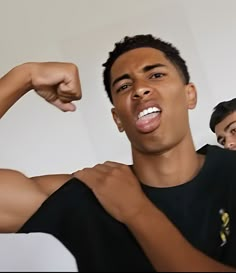 two young men flexing their muscles for the camera