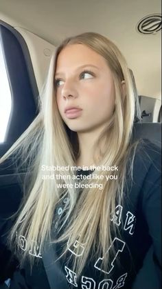 a woman with long blonde hair sitting in a car