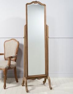 a tall mirror sitting next to a chair on top of a white floor covered in furniture