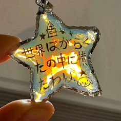 someone holding up a star shaped ornament with writing on it's side