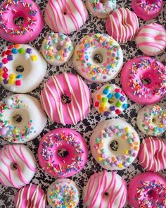 there are many donuts with pink frosting and sprinkles on them