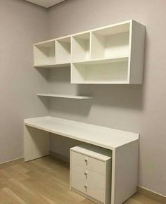 an empty room with white shelves and drawers