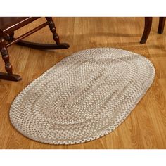 a white rug on the floor in front of a rocking chair and wooden flooring