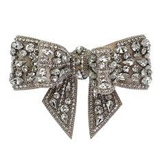 a large bow brooch with lots of diamonds on it's side, sitting in front of a white background