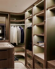 a walk in closet with lots of shelves and drawers