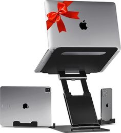 an apple laptop with a red bow on it's cover and another device attached to the stand