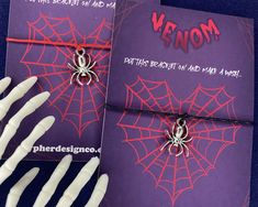 two halloween greeting cards with fake hands and spider webs on them, one is purple and the other is red