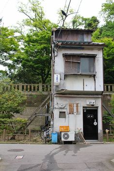 an old building with a bicycle parked in front of it on the side of the road