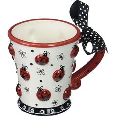 a ladybug coffee mug with polka dots on it and a bow in the middle