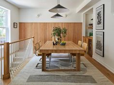 a wooden table sitting in the middle of a living room next to a stair case