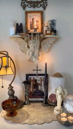 a table topped with candles and pictures next to a wall mounted above it's head