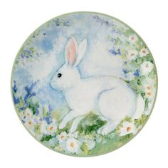 a white rabbit sitting on top of a field of flowers