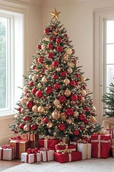 a christmas tree with red and gold ornaments is surrounded by presents in front of a window