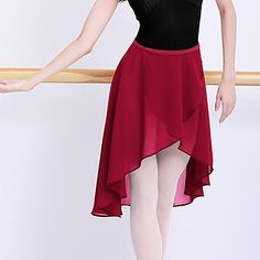 a woman in a black top and red skirt is posing for the camera with her arms outstretched