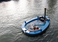 a man laying in the middle of a body of water on top of a boat