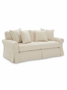 a white couch with several pillows on top of it and the bottom row is lined up