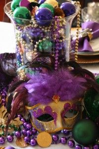 purple and green mardi gras decorations on a table