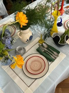 the table is set with flowers and plates