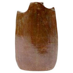 a brown vase sitting on top of a white surface