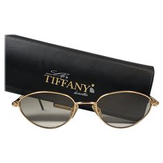 New Tiffany gold plated cat eyes frame. Spotless brown gradient lenses. Made in Italy. Produced and design in 1990's. This item may show minor sign of wear due to storage. 1960s Sunglasses, Tiffany Gold, Tiffany Rose, Black Round Sunglasses, Gold Glasses, Sunglasses Logo, Vintage Tiffany, Cat Woman, Chanel Sunglasses