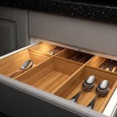 an open drawer with utensils and spoons in it