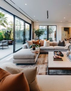 a living room filled with lots of furniture and large glass doors leading to an outside patio