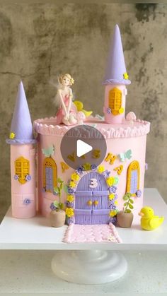 a pink castle cake with a little fairy on top